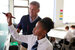 supply teacher helps student at whiteboard