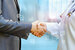 Medical officer and shaking hands with businessman on blurred background.