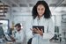 Woman with tablet smiling in laboratory with medical data