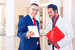 man in suit and glasses holding a tablet up to a man wearing a lab coat