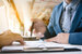 businessman hand holding pen above documents