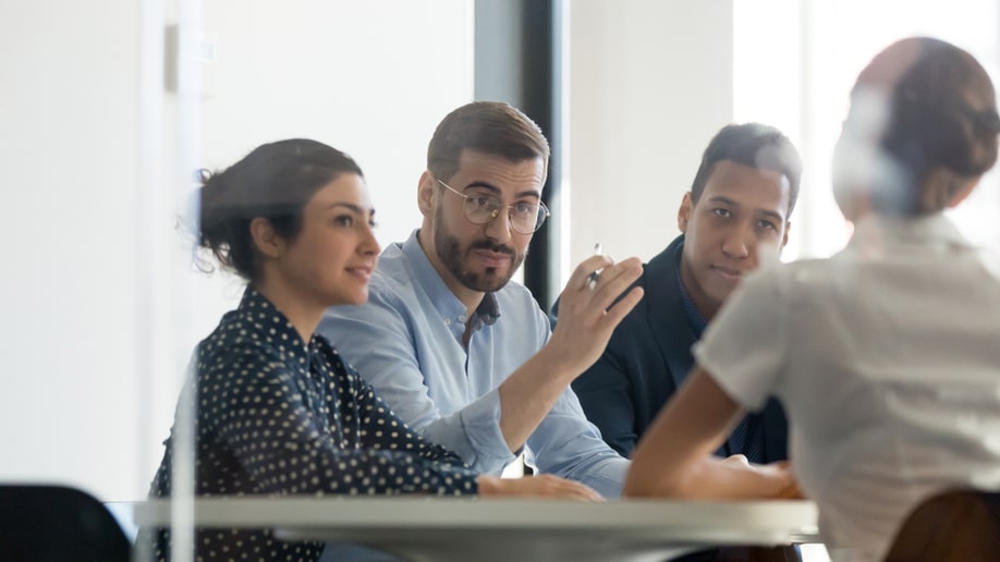 pharma sales representative negotiating at diverse group meeting