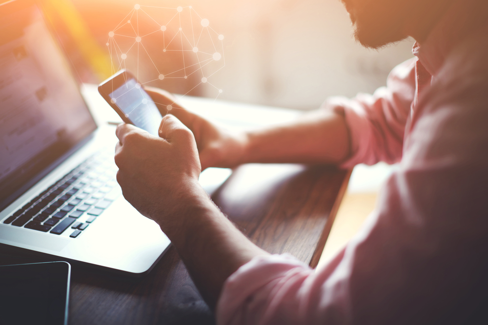 man on phone and laptop online networking