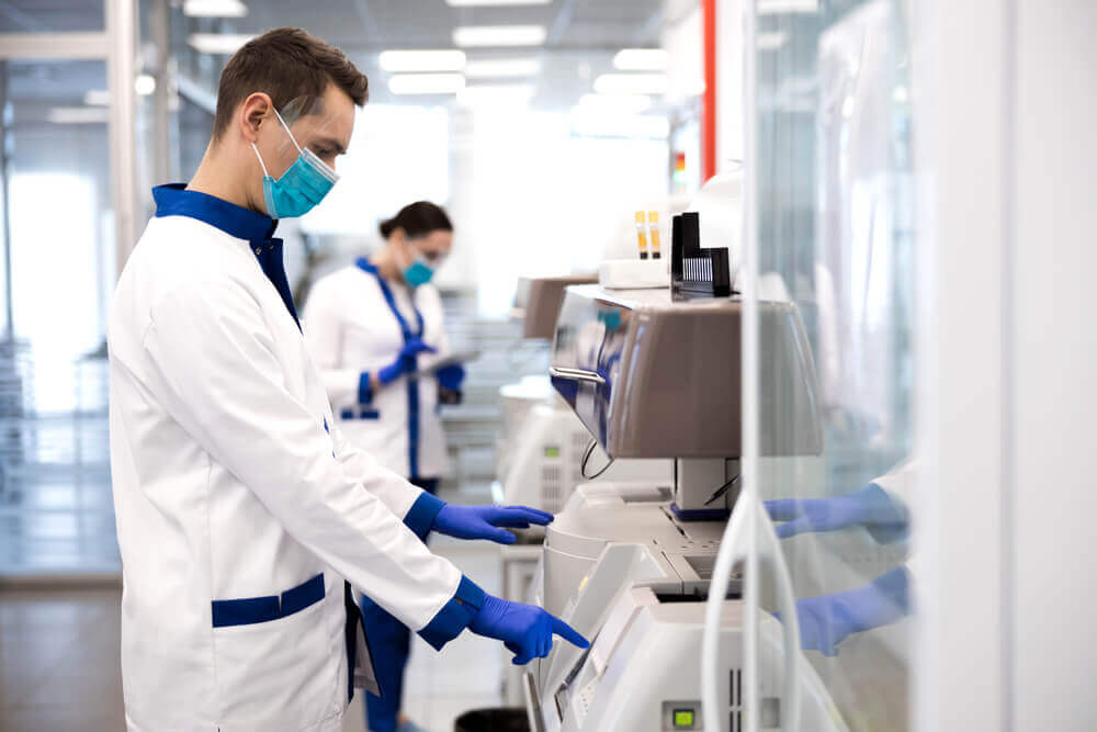 man using a machine wearing PPE