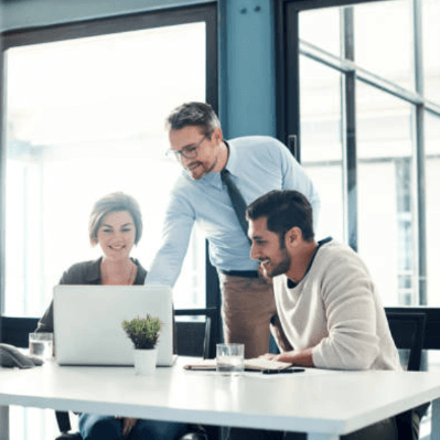 employees pointing at a laptop screen