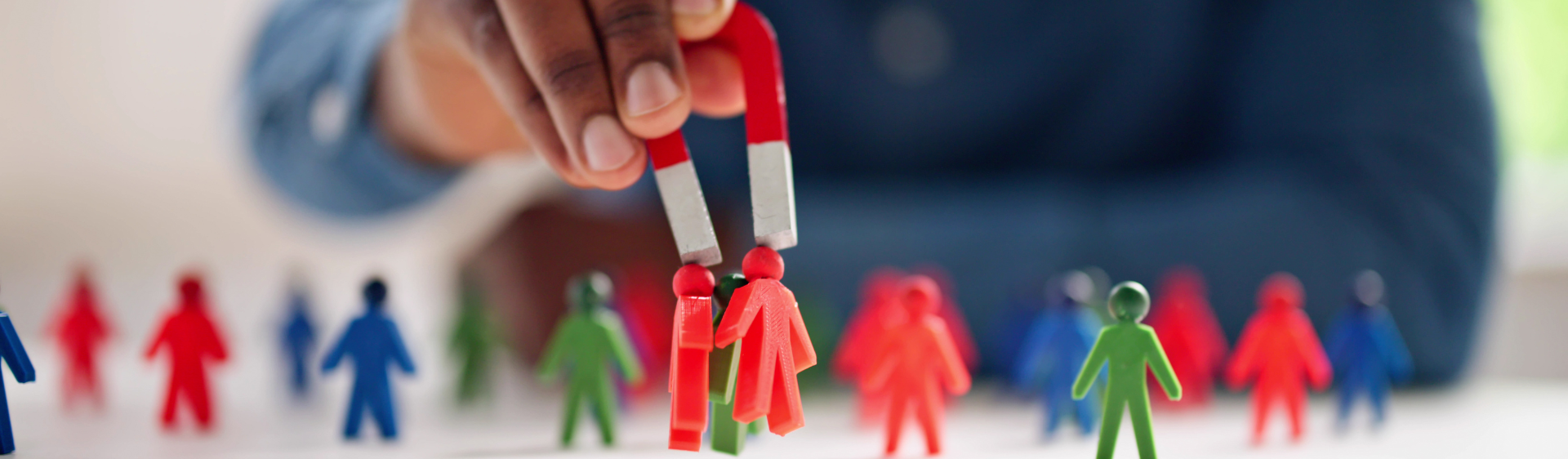 Man using magnet to lift plastic persons