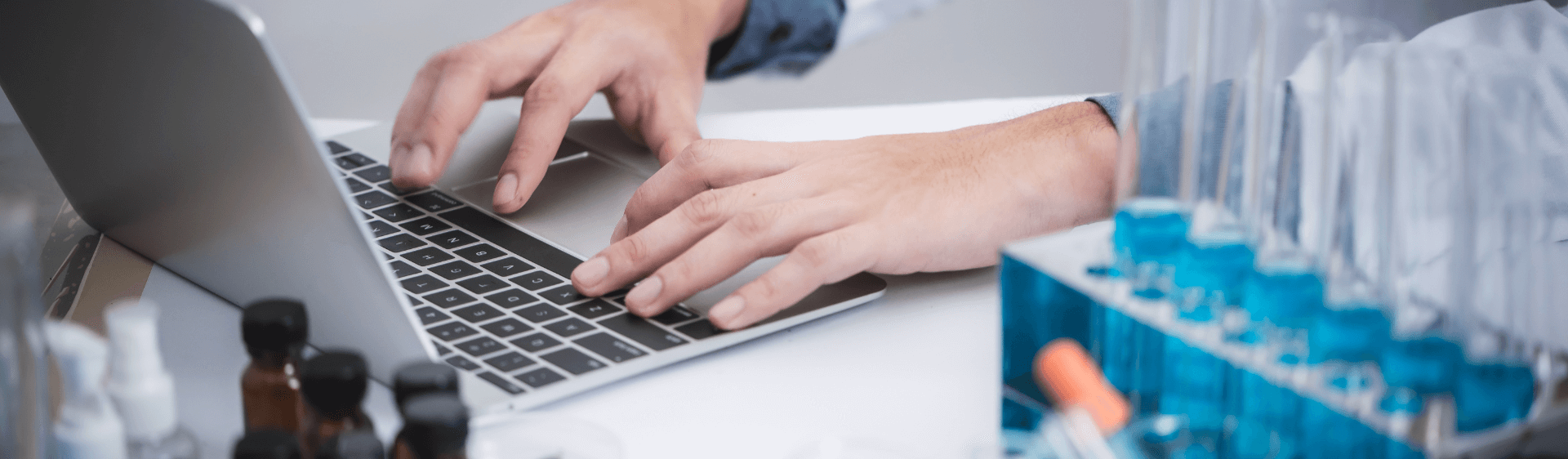 Two hands typing on a laptop keyboard