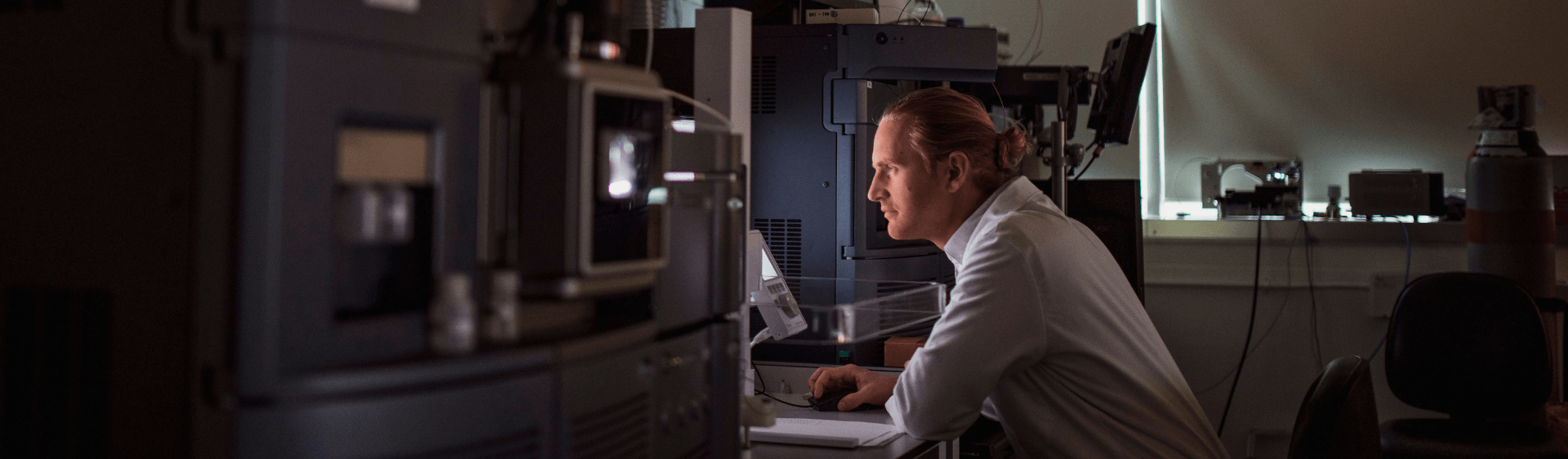 Man in lab coat reading computer