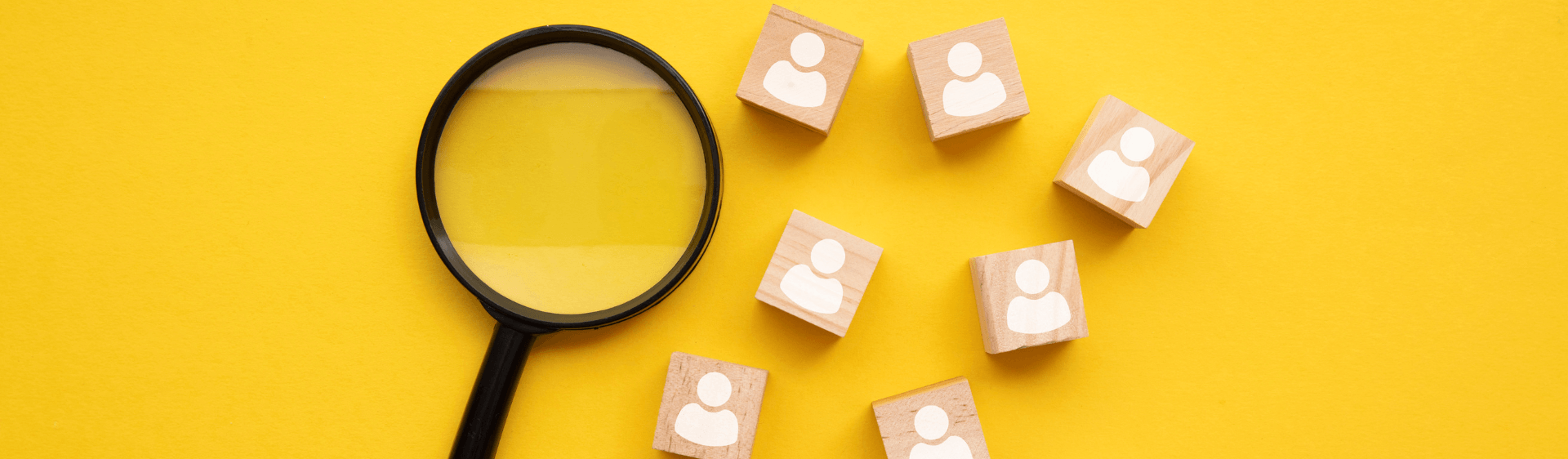 Magnifying glass and wooden blocks with caricatures on it