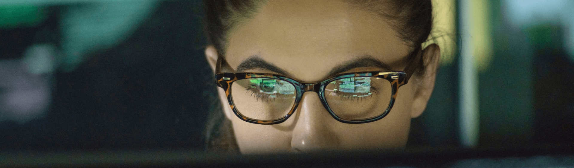 Female with glasses looking at a screen