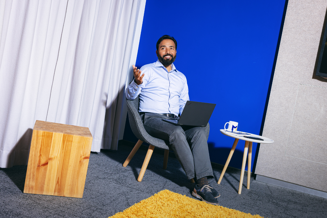 a professional sitting on a chair with his laptop