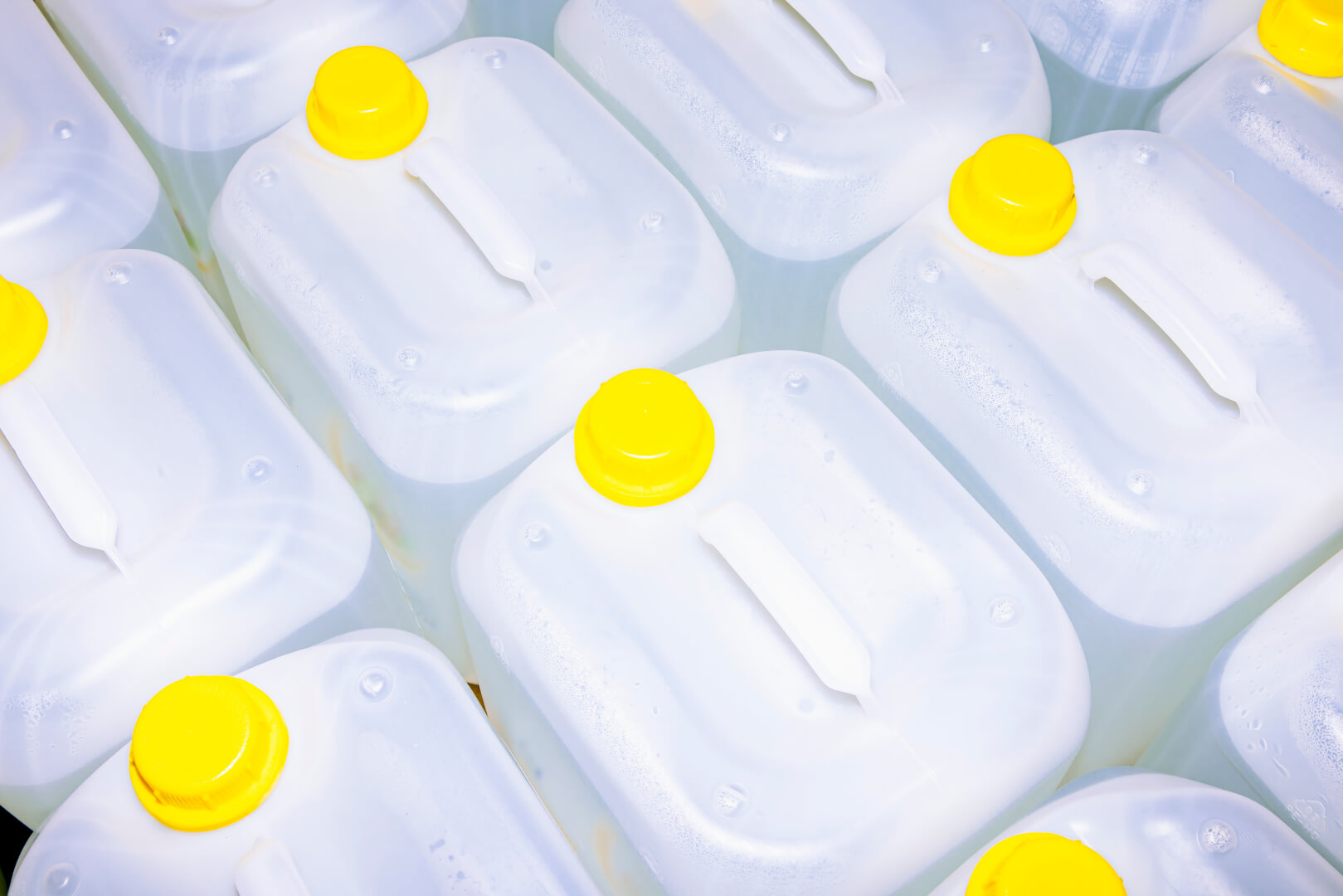 large white liquid containers with yellow caps