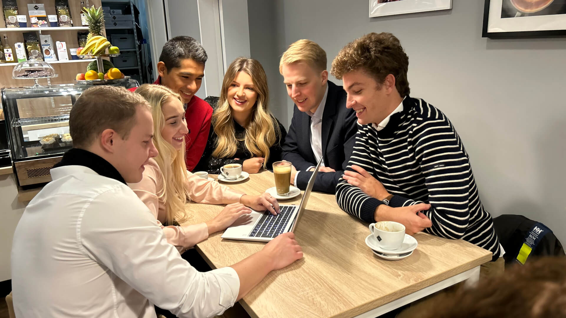 a group of young people engrossed in a discussion and looking at the laptop