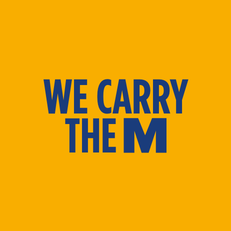 part 1 of the company manifesto that reads we carry the m written in a bold, blue font across an orange backdrop 