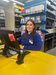Toolstation employee at branch desk with a computer and shelves in background 