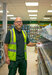 Richard Humphreys - Travis Perkins employee with yellow vest standing next to shelves