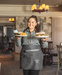 Smiling waitress with two plates in hand 