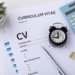 image of a CV template with a pen, little clock, and calculator on top