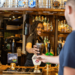 Customer service job - bar staff serving a drink to a customer