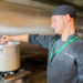 Chef at Greene King in the kitchen handing over a plate of food 