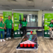 Greene King employees wearing green t-shirts stood in front of a beer pong table.