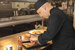 chef in a black outfit, preparing food on a counter ready for serving