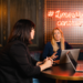 Two Greene King staff members sat at a table with laptops