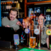 Three greene king staff behind the bar