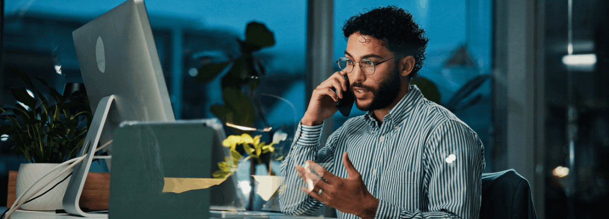 IT professional on a phone call sat at their desk