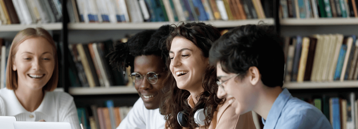 students in a library smiling.