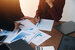 marketing business people point to graphs and charts to analyze market data, balance sheet,