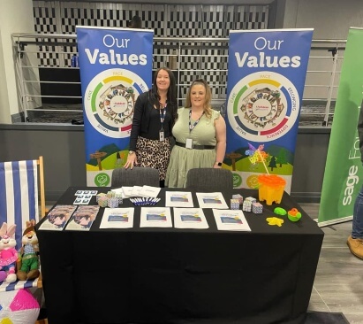 Image of Emily behind a recruitment stand