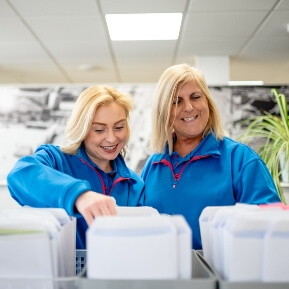 Image of receptionists sifting through holiday park key packs smiling