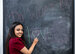 Image of smiling team member writing 'do what you love' on a chalkboard