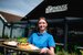 A woman in a blue t shirt holding a tray of food