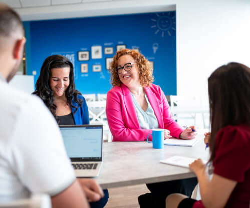 Image of 4 colleagues sat around a table in conversation