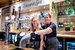 two members of the Parkdean bar team standing behind the bar and smiling together.