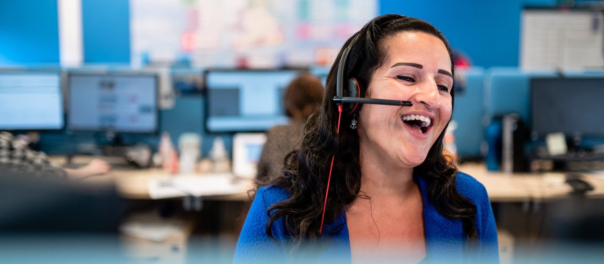 Image of a woman wearing a head set laughing