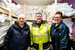 Three women stood smiling at the camera in the linen storage room.