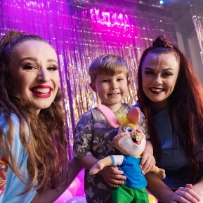 image of a child smiling, holding a toy, next to two smiling children's entertainers