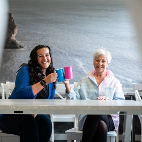 Image of two people chatting over a cup of tea