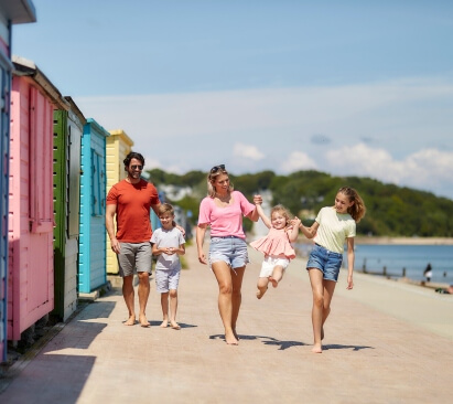 image of a family walking along the beach