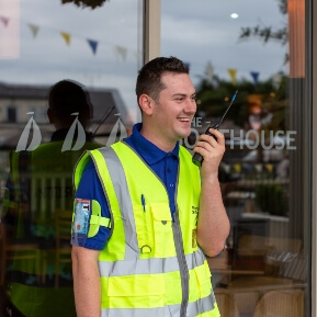 image of security guard smiling as he speaks into his radio