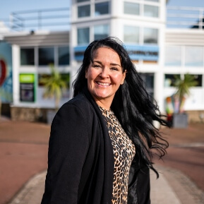 Image of a woman stood outside a holiday park complex smiling