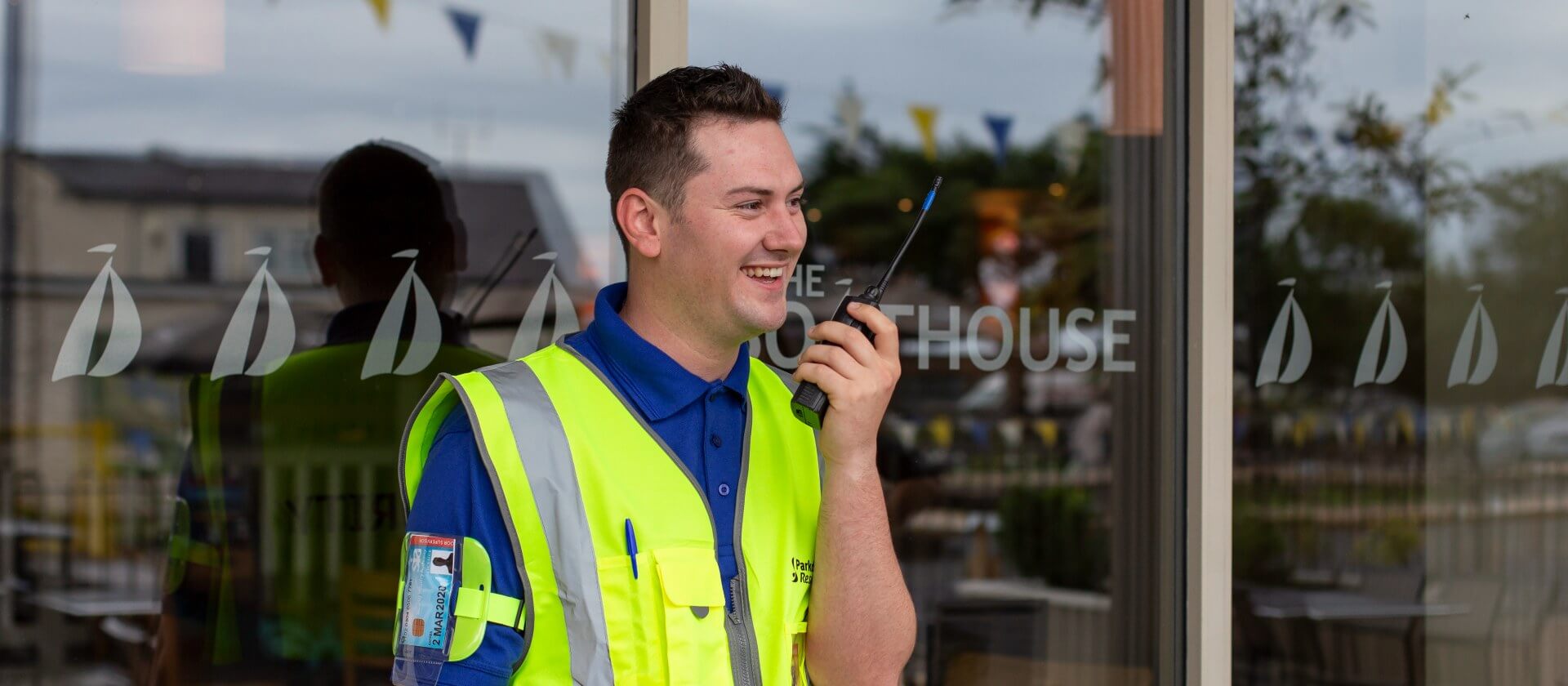 Image of a security officer in high vis talking into a radio