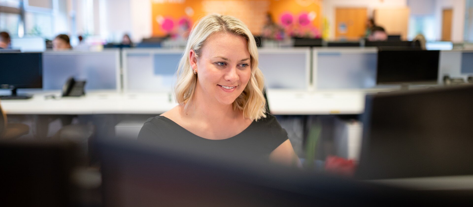 Image of woman looking at computer monitor smiling