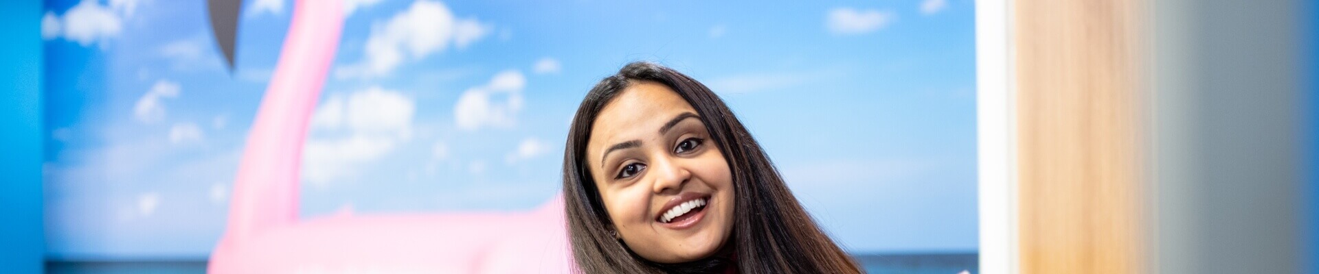 Image of woman looking over her should and smiling at the camera