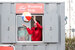 a man in a red jacket in a window throwing a beach ball