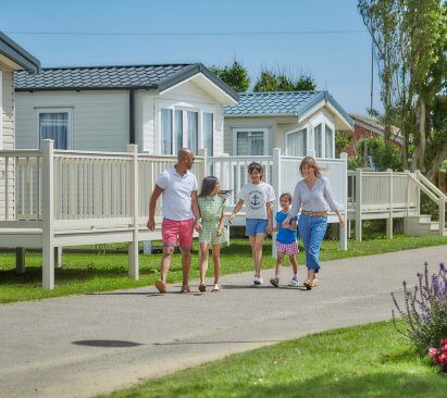 Image of a family walking hand in hand through California Cliffs Holiday Park