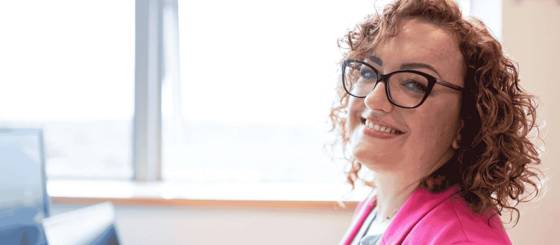 Image of a women smiling at her desk